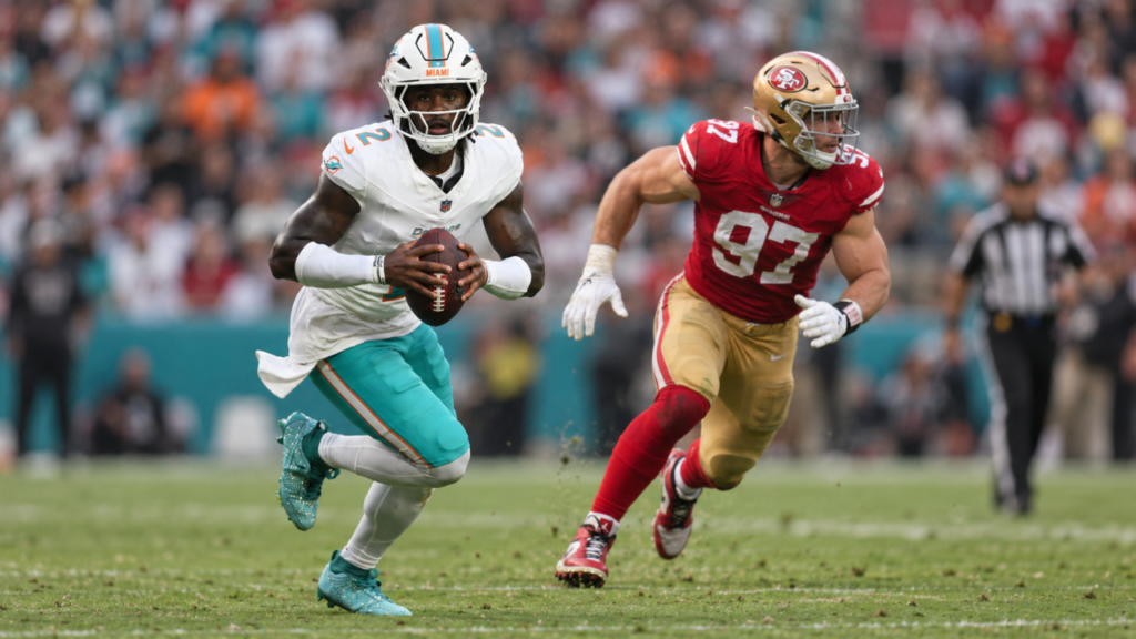 Miami Dolphins quarterback Malik Willis runs with the football as 49ers defensive end Nick Bosa pursues.