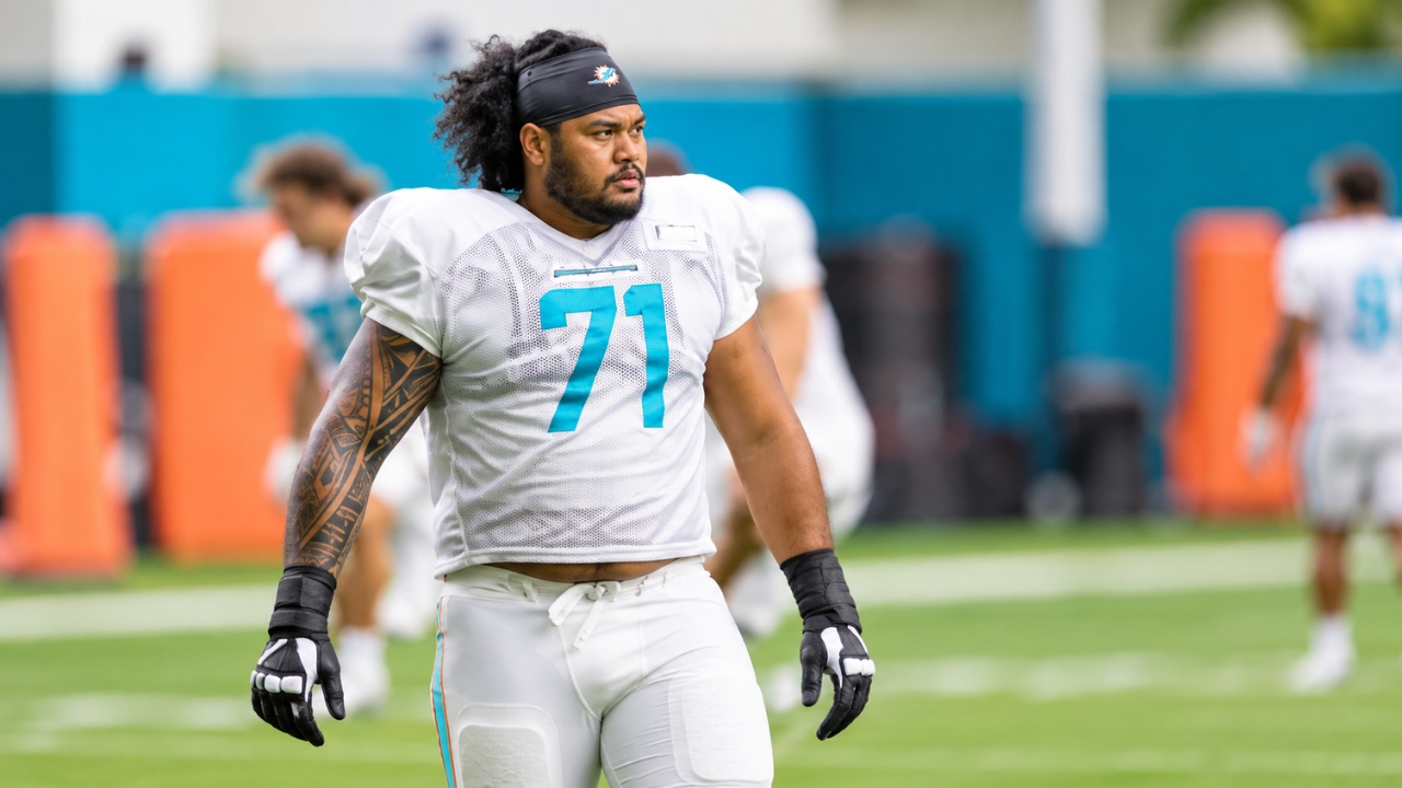Jonah Savaiinaea, wearing No. 71, at Miami Dolphins practice.