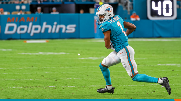 Miami Dolphins wide receiver Jalen Tolbert runs with the ball in his aqua No. 1 jersey